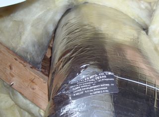 Air leakage through the duct penetration shows up because of the dirty fiberglass insulation.